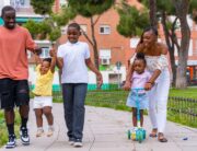 A Black mother and Black father co-parenting their children and having fun outside as a family.