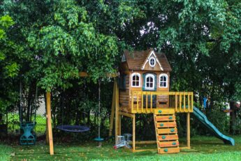 A family backyard with a fun playground set perfect for ages 3 to 10 with swings, climbing, and a treehouse.