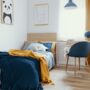 A kids room with a twin-size bed, a desk, and a bookcase. The color theme is navy and mustard with animals.