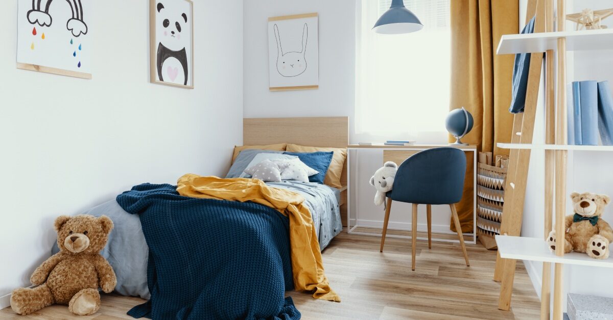 A kids room with a twin-size bed, a desk, and a bookcase. The color theme is navy and mustard with animals.